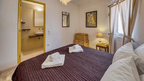 A bedroom with a large bed, a bedside table with a lamp, a mirror, and a painting on the wall. - Casa Ocean View - 180 degrees sea view (Carvoeiro)