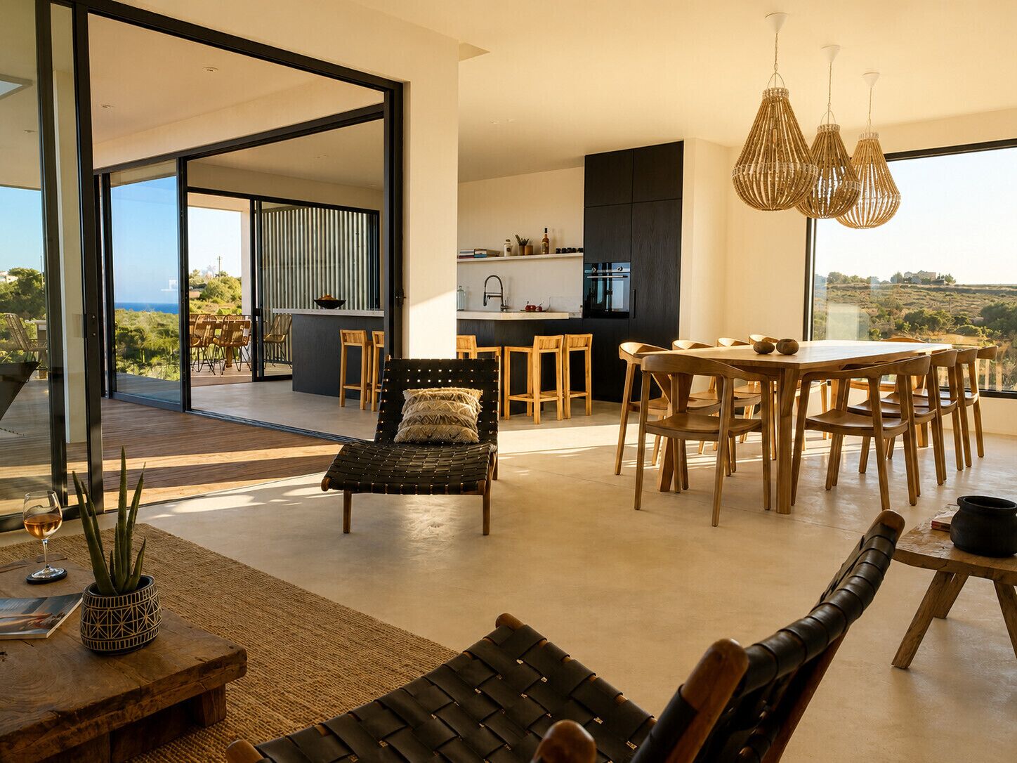 A modern interior with a dining area, kitchen, and a view of the outdoors.