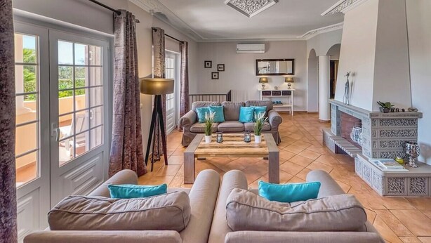 A spacious living room with a sofa set, a coffee table, and a fireplace.