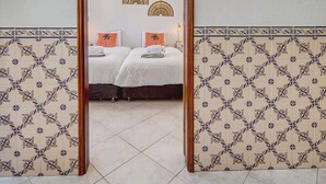 Ein Hotelzimmer mit einem großen Spiegel, einem Bett mit weißer Bettwäsche und dekorativen Wandleuchten.