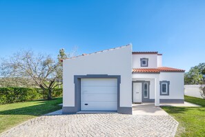 A modern two-story house with a white facade, a red-tiled roof, and a paved driveway. - Casa Bougainvilla - Lovely Villa walking distance to Carvoeiro (Carvoeiro)