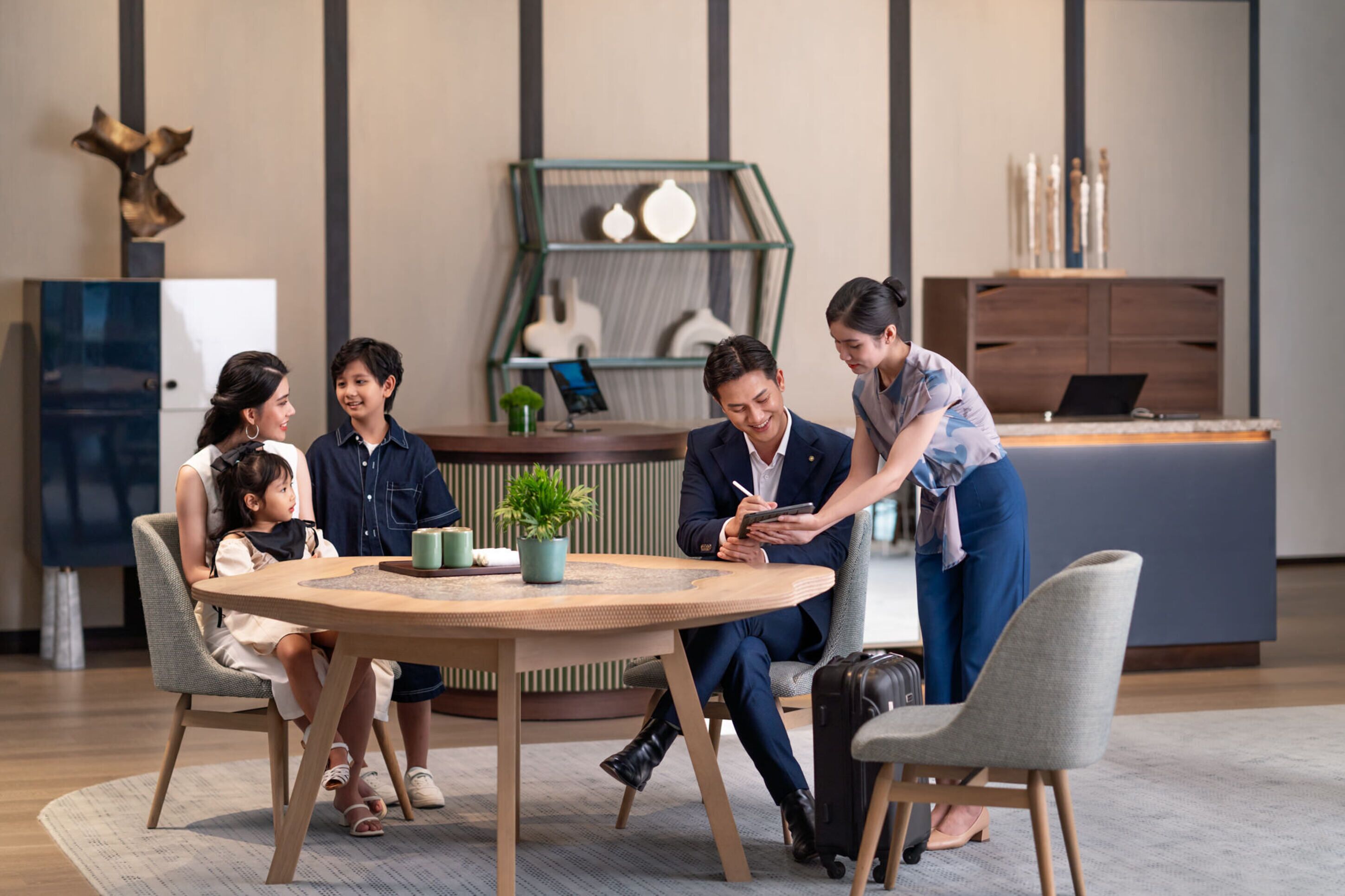 A modern meeting room with a round table, chairs, and a laptop.