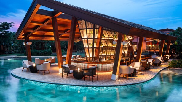 A poolside lounge with a bar, wooden deck, and seating area. - New World Hoiana Beach Resort (Da Nang)