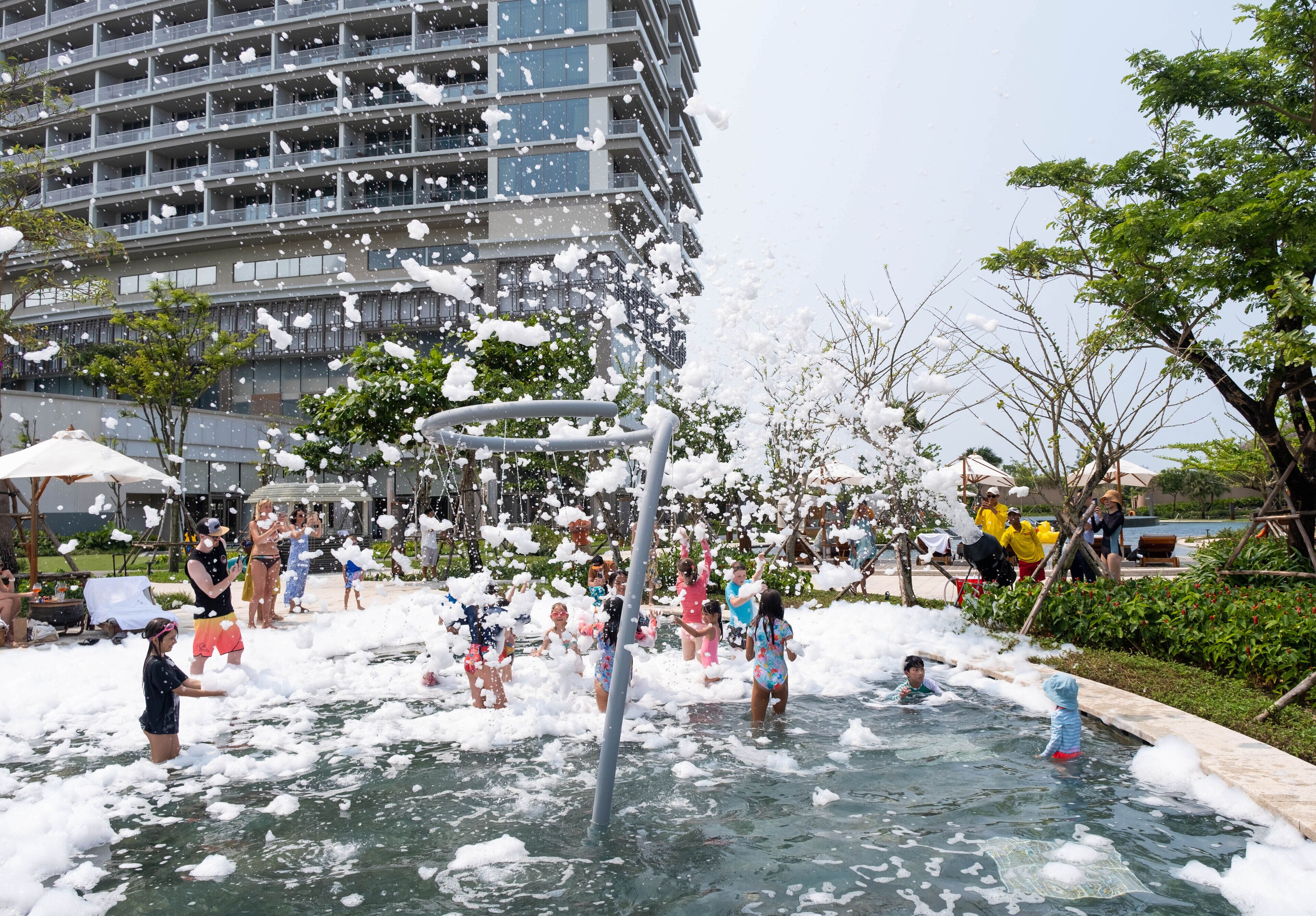 A water play area with children and adults enjoying the foam.