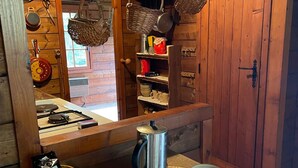 Une cuisine rustique avec des meubles en bois, un poêle et divers ustensiles de cuisine.