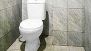 A bathroom with a toilet and a wall-mounted bidet. - Hotel O Wisma Heksa (Batam)