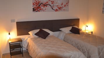 Un letto matrimoniale con testiera, due comodini con lampade e un'opera d'arte appesa al muro.