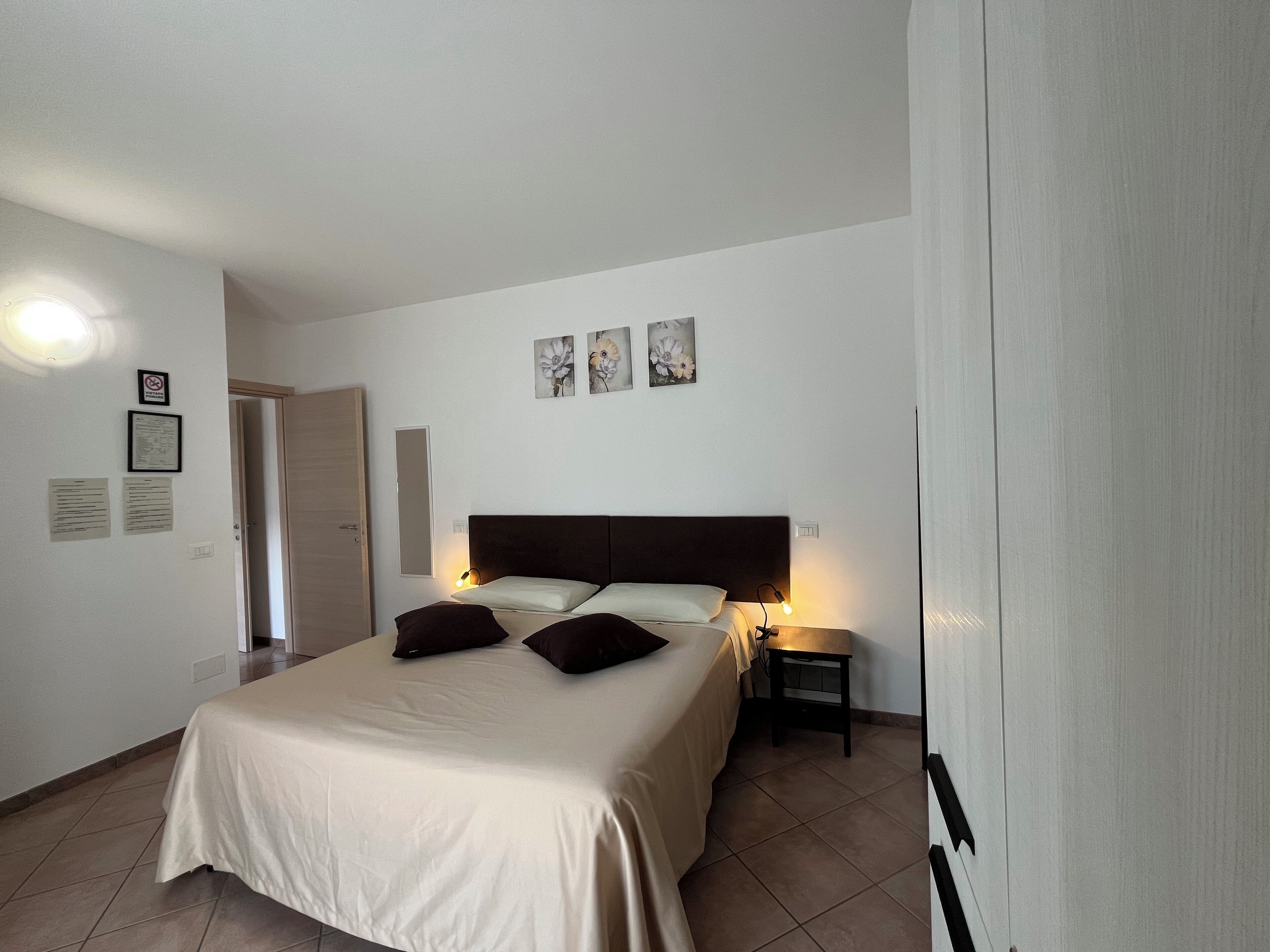 Ein Schlafzimmer mit Bett, Nachttischen und einem Wandbild.