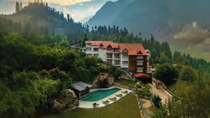 Un complexe hôtelier doté d’une piscine, de plusieurs bâtiments et situé dans un cadre montagneux.