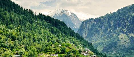 Une région montagneuse où un village est niché au milieu de collines verdoyantes.