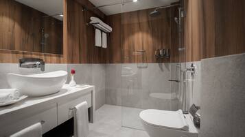 Un baño moderno con un lavamanos grande, inodoro y ducha.