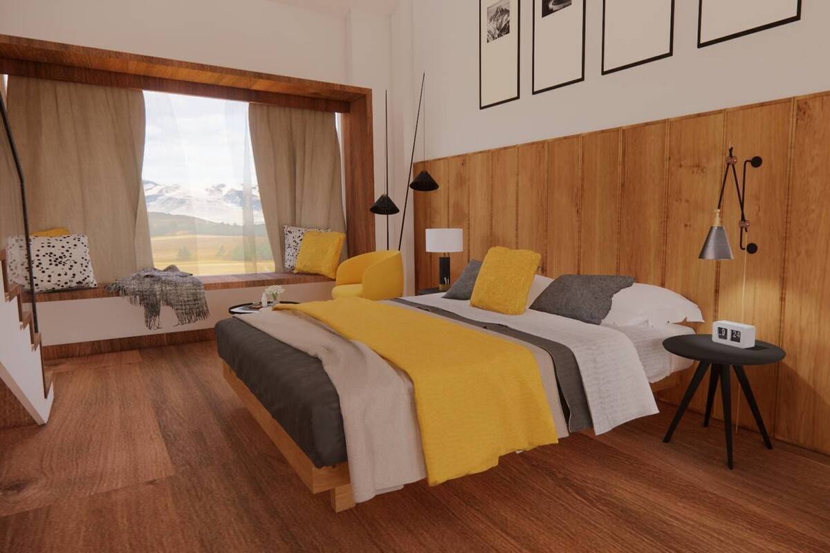 A modern hotel room with a wooden headboard, a large bed with multiple pillows, a bedside table with a lamp, and a window with a view of mountains.