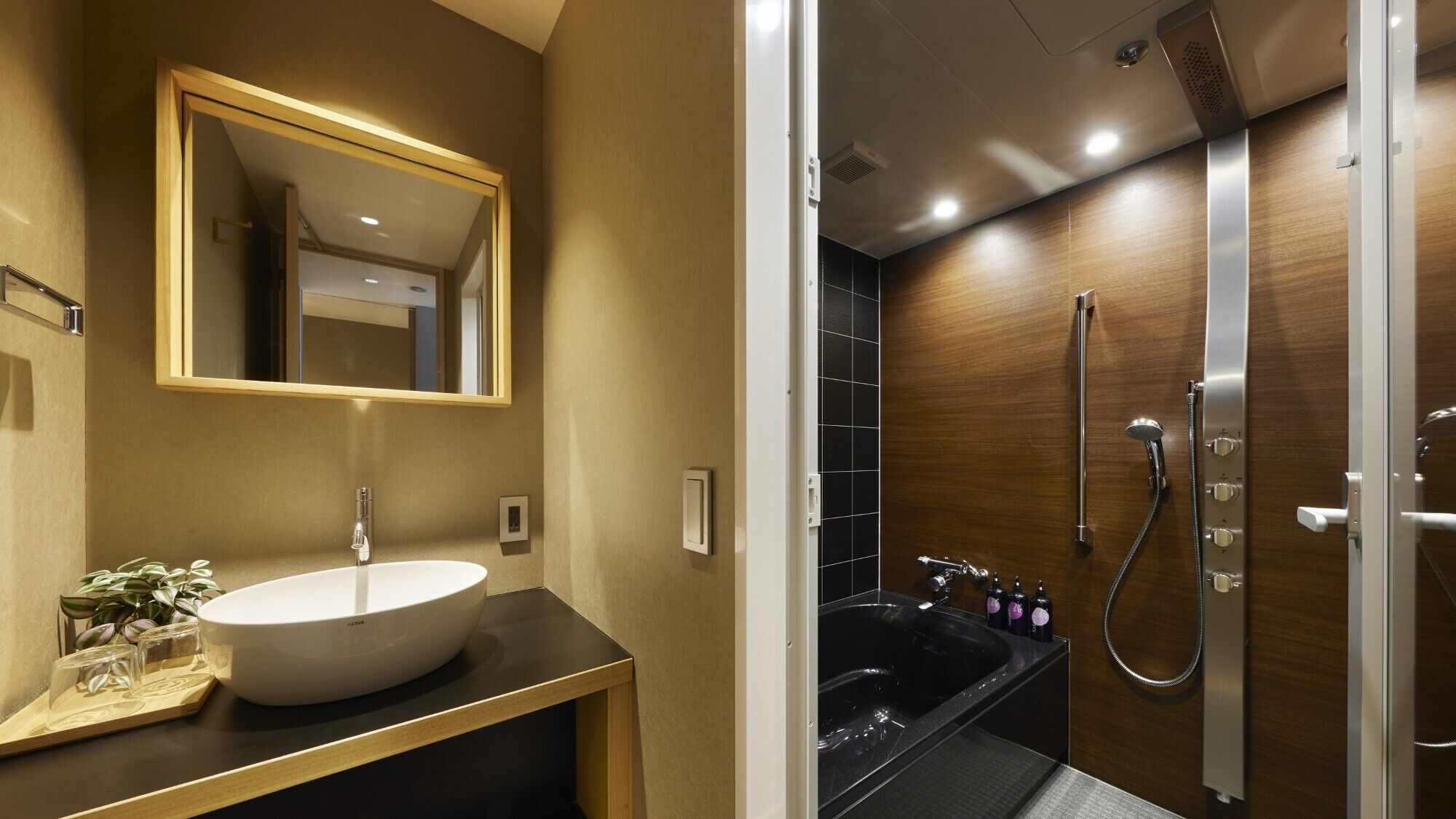A modern bathroom with a large mirror, a round sink, and a separate shower area.