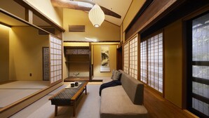 A traditional Japanese room with tatami flooring, a low table, a sofa, and sliding doors. - Minn Nijo-jo (Kyoto)