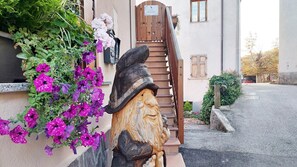 A rustic stone lion statue with a wooden door and steps leading to a house labeled "Casa Bernardi." - LE RONDINI 3 rooms Wi-Fi sun nature pet friendly panoramic veranda (Montagnaga di Pinè)