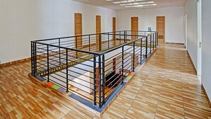 A spacious interior with a wooden floor, a mezzanine level with a metal railing, and skylights on the ceiling. - OYO Life 91989 K24 Residence Syariah (Palembang)