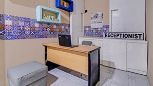A reception area with a desk, a computer, and a sign labeled "RECEPTIONIST".