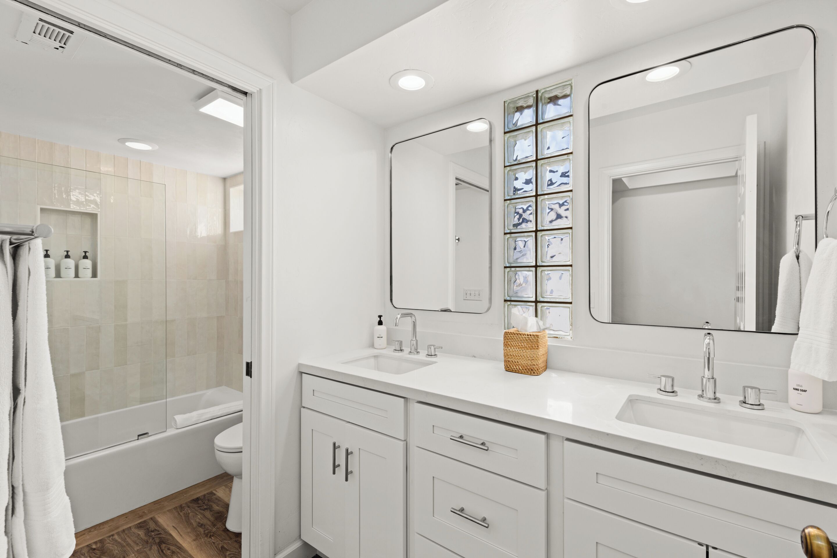 A modern bathroom with a bathtub, a shower, and a vanity with a mirror.