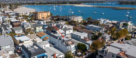 A coastal town with a marina, residential buildings, and a bridge in the background.