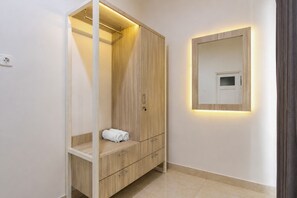 A modern bathroom with a wooden vanity, a mirror, and a towel rack. - Collection O near Ambarrukmo Plaza Mall formerly Damar Kusumo Guest House (Depok)