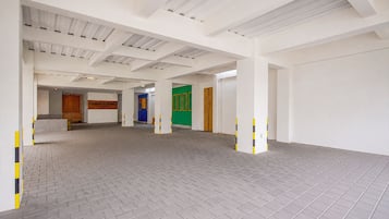 Un amplio espacio interior con techo alto y suelo de baldosas.
