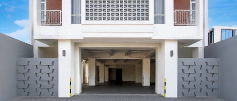 A modern building with a central entrance, two balconies, and a patterned facade.