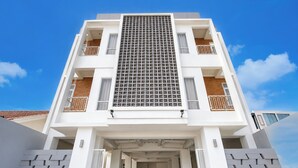 Un edificio de varios pisos con un atrio central, balcones y una fachada con diseño.