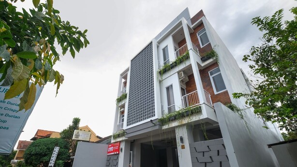 Un edificio moderno con techo plano, amplia entrada y un cartel que indica un negocio o servicio.