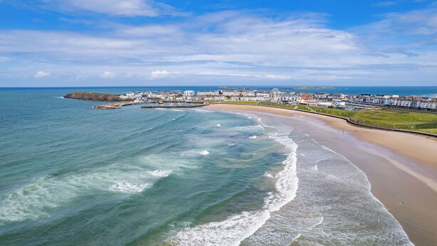 A coastal town with a sandy beach, a pier, and a large Ferris wheel. - Dunluce Park - Portrush by the Sea (Portrush)