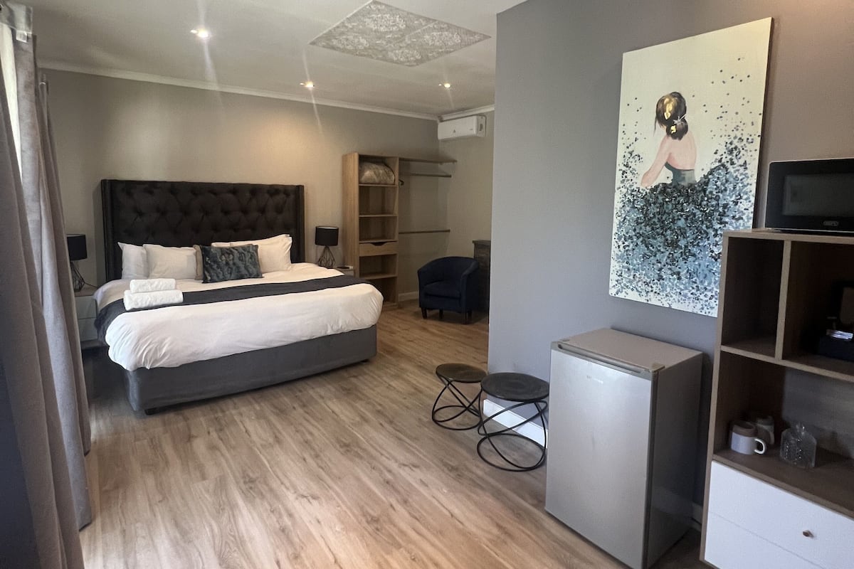 Un dormitorio moderno con una cama grande, un escritorio y una silla.
