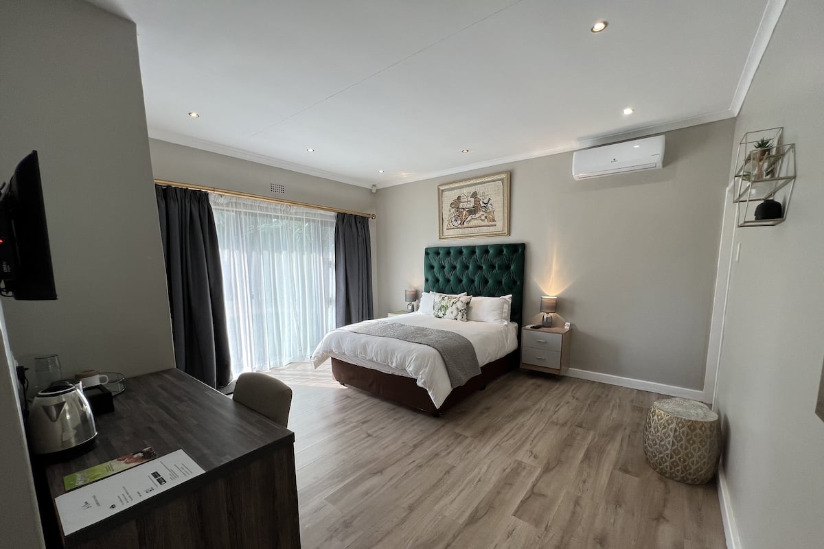 Un dormitorio moderno con una cama grande, un escritorio y una silla.