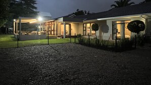 A modern house with a covered patio area, a visible garage, and a well-maintained lawn. - Le Ciara (Randburg)