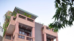 A multi-story building with balconies, a gated entrance, and surrounding greenery. - Michaels Homestay (Jaipur)