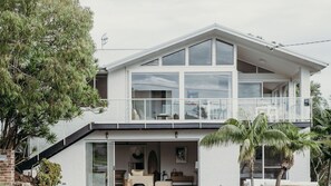 A modern two-story house with large windows, a balcony, and a garage. - Baybreeze, 18 Tomaree Road - WiFi, Air Conditioning, Kitchenette (Shoal Bay)
