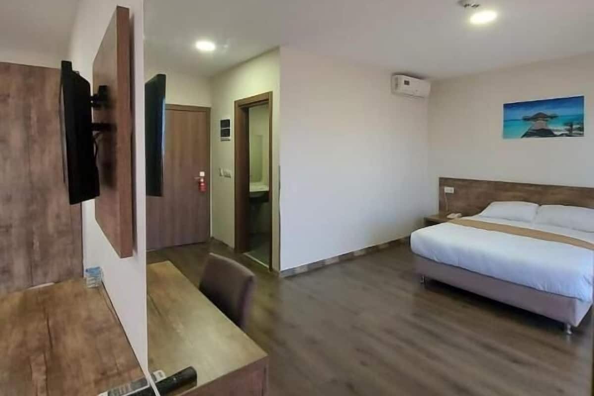 Relax in a stylish room with a large bed, flat-screen TV, and desk area.