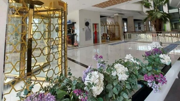 A spacious lobby with a modern design, featuring a glass partition with geometric patterns, a polished floor, and decorative plants. - ipsala park hotel (Ipsala)