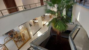 A multi-level atrium with a central water feature, a palm tree, and a patterned floor. - ipsala park hotel (Ipsala)