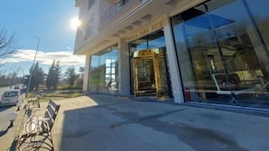 A hotel with a modern facade, large glass entrance, and a parking area with benches. - ipsala park hotel (Ipsala)