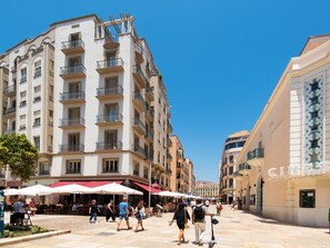 A multi-story building with balconies, outdoor seating, and a clear blue sky. - Central Picasso Apartment Art location (MALAGA)