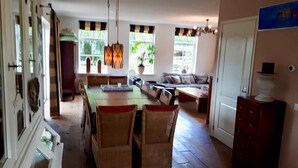 A spacious kitchen with a dining area, wooden flooring, and large windows. - Villa Martensplek with sauna, 10 pers + 2 toddlers (Tiendeveen)
