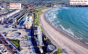 Enjoy a coastal view with beach access from this spacious apartment, featuring multiple rooms and a garden, plus a swimming pool and outdoor area.