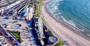 Vista aérea de los Apartamentos West Beach, con playa y paseo marítimo.