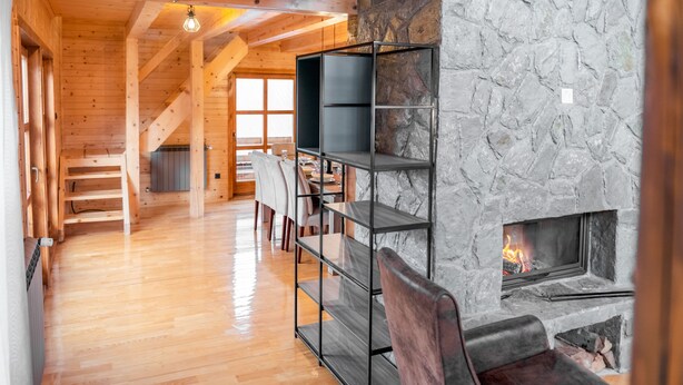 A cozy interior with a stone fireplace, wooden beams, and a staircase leading to another level. - Stay at Mountain Boy, the ultimate mountain retreat in Kolasin (Kolasin)