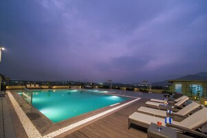 Una piscina al aire libre, sillones reclinables de piscina