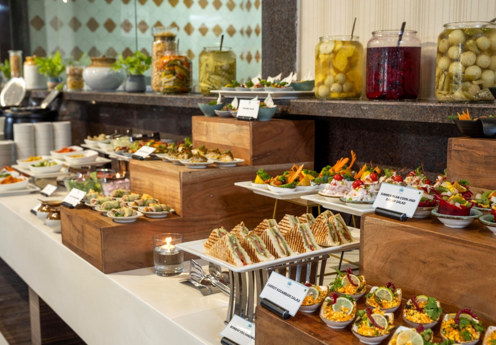 A buffet with various dishes, including salads, sandwiches, and pickled items.