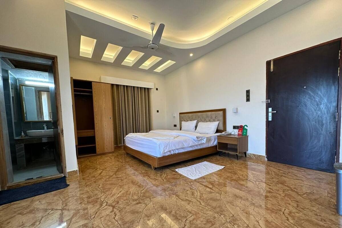 Ein modernes Schlafzimmer mit einem großen Bett, einem Kleiderschrank, einem Schminktisch und einem Deckenventilator.