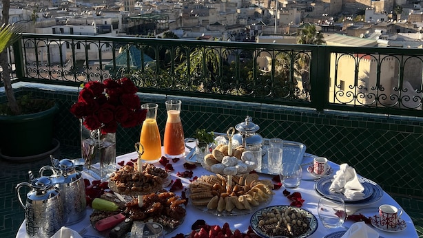 A table set for a meal with a city view in the background. - Palais de Fès Suites & Spa (Fes)