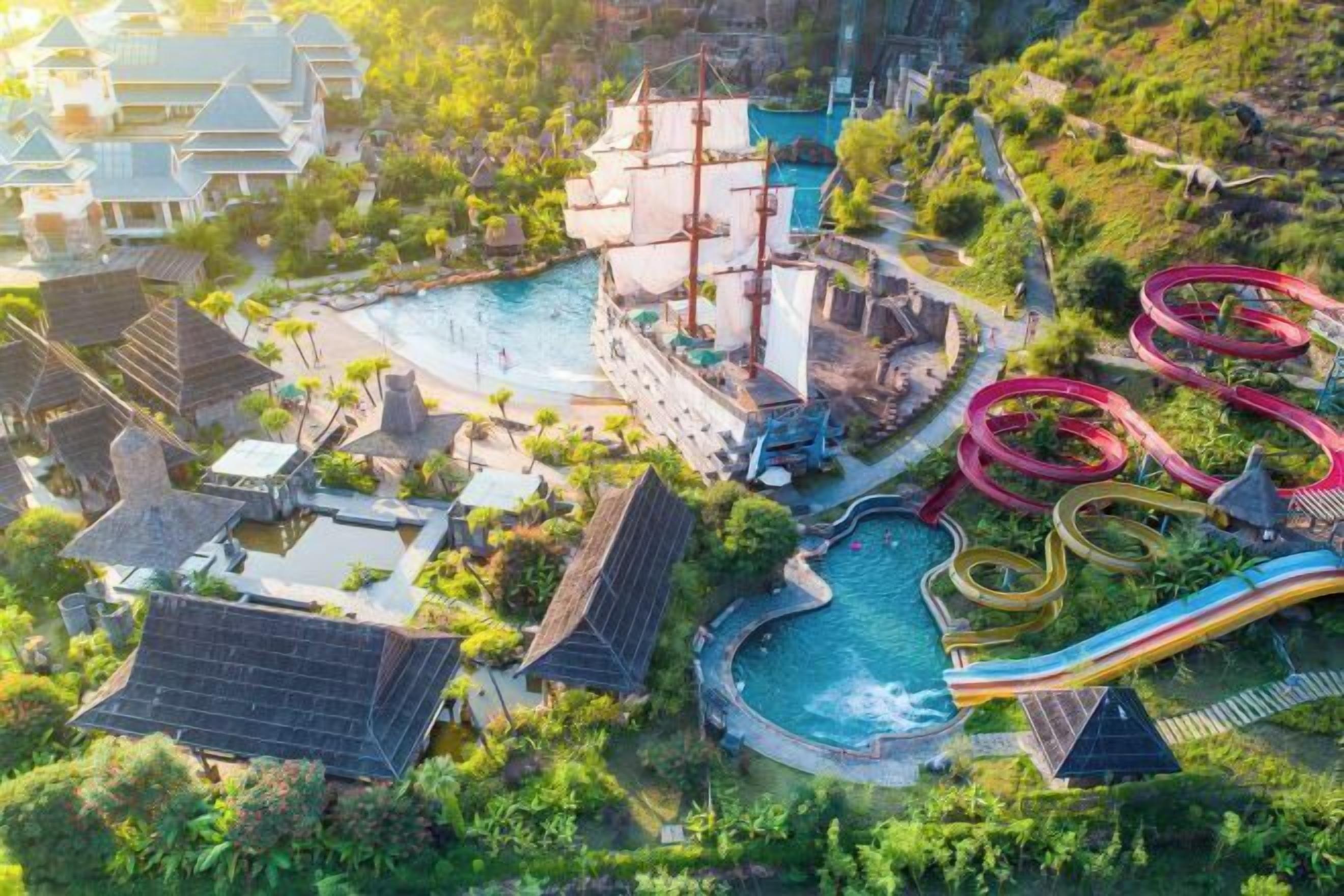 Vista aérea de un resort con una piscina grande, un barco pirata y varias toboganes de agua.