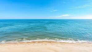 Una playa con aguas azules cristalinas y una orilla arenosa.