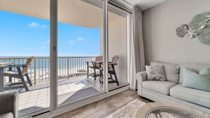 A balcony with a view of the beach, a sofa, and a coffee table. - Beach Baby 808/ Beachfront Beauty/ The Beach Club (Gulf Shores)